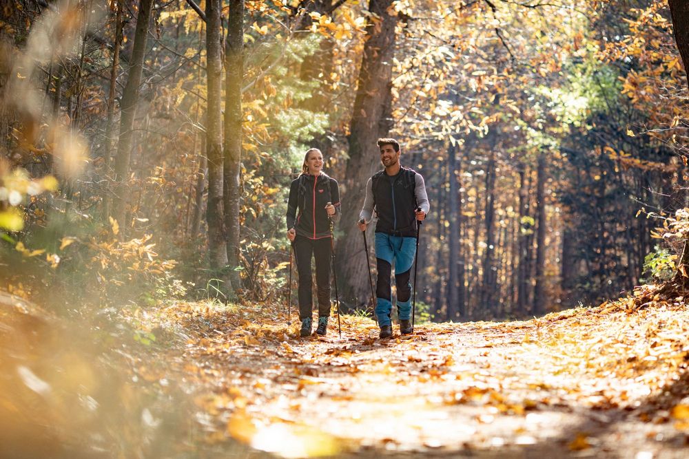 Paar beim herbstlichen Wandern durch den Wald bei Eppan in Südtirol – Naturgenuss und Aktivurlaub in der Umgebung der Ferienwohnungen Urbanhof in Girlan.